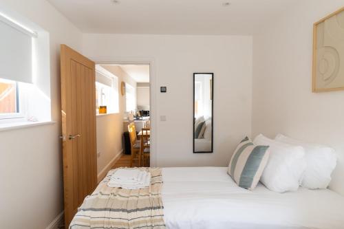 a bedroom with a bed with white sheets and pillows at Stylish 2-Bedroom Stay with All Comforts of Home # 2 in Rothley