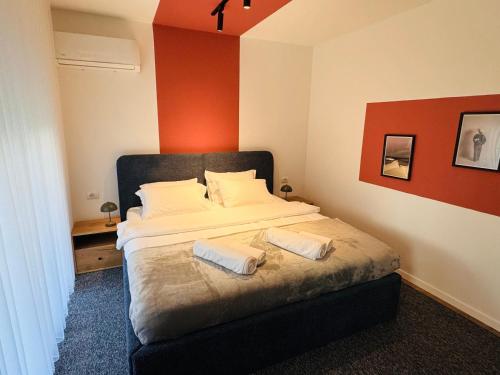 a bedroom with a bed with two pillows on it at Urban Apartments CityCenter in Gjakove