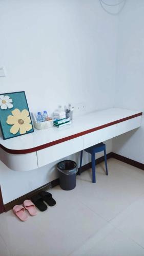 a white desk with a pair of shoes under it at Mushe Inn 