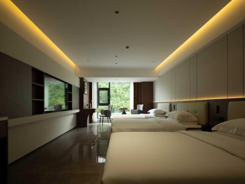 a hotel room with two beds and a living room at 张家界叁禾溪居-Free one way pick up service over 2 nights in Zhangjiajie