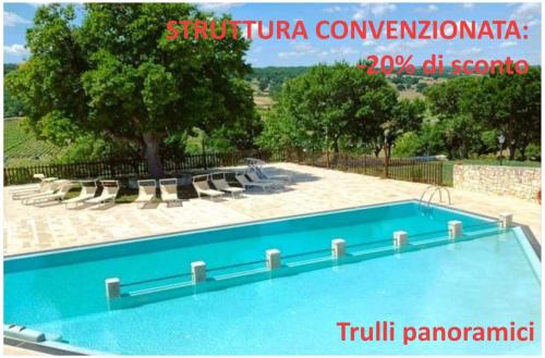 a blue swimming pool with chairs and a tree at Da Nonna Filomena in Alberobello