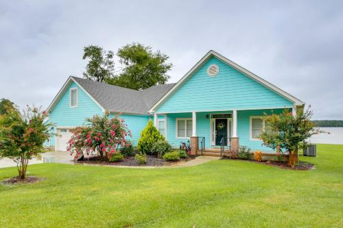 a blue house with a yard at Lakefront Home with Hot Tub and Dock in Cross Hill! in Cross Hill
