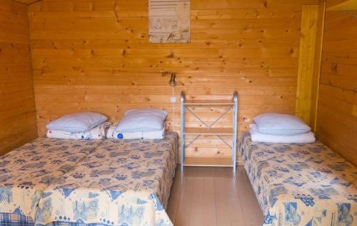 Duas camas num quarto com paredes de madeira em Poilsio nameliai Jūros 67 em Šventoji