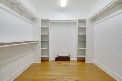a walk in closet with white walls and wooden floors at Lakefront Home with Hot Tub and Dock in Cross Hill! in Cross Hill