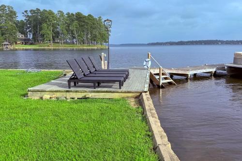a bench sitting on a dock next to the water at Lakefront Home with Hot Tub and Dock in Cross Hill! in Cross Hill