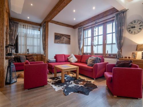 a living room with red furniture and a clock on the wall at Alpine Apartment near Kaprun in Piesendorf