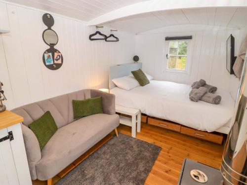 a living room with a couch and a bed at King's Cwtch Shepherd's Hut in Cardiff