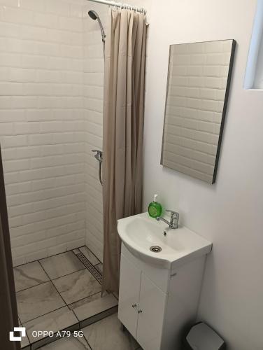 a bathroom with a sink and a shower with a mirror at Marea Albastră in Eforie Sud
