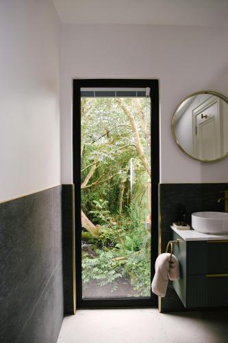a bathroom with a door leading to a garden at Riverside Retreat in Monaghan