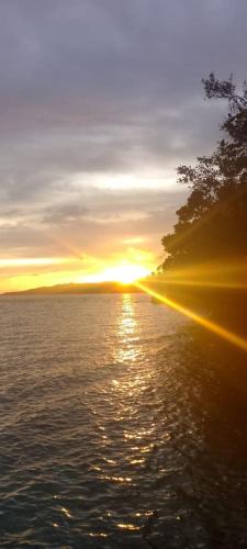 a sunset over a body of water at "Shady Sea Raja Ampat" in Besir