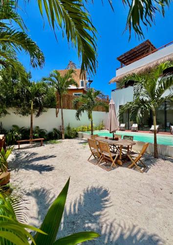 a resort with a pool and a table and chairs at Villa Paraiso in Holbox Island