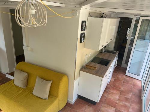 a living room with a yellow couch and a kitchen at Appartamenti Sterlizia 2 in Lacona