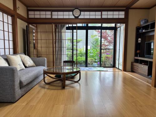 a living room with a couch and a glass table at 世界文化遗产三保松原 徒步3分钟 和服体验 160平独栋日式民居 民宿 松原 in Shizuoka