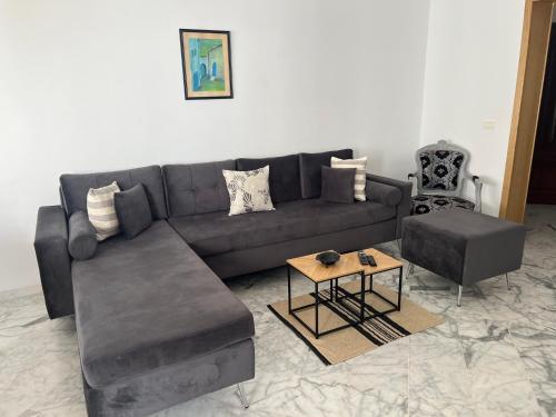a living room with a couch and a table at Appartement meublé in La Soukra