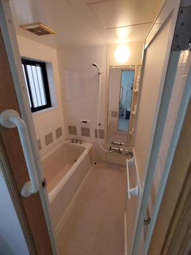 a bathroom with a tub and a sink and a mirror at 世界文化遗产三保松原 徒步3分钟 和服体验 160平独栋日式民居 民宿 松原 in Shizuoka