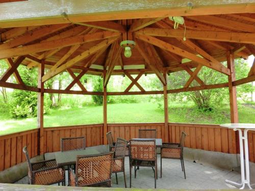 a wooden pavilion with tables and chairs on a patio at Retreat in the Ore Mountains in Wünschendorf