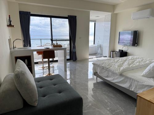 Un dormitorio con una cama, un sofá y un escritorio. en 微笑海之夕潮弄海旅居, en Hengchun