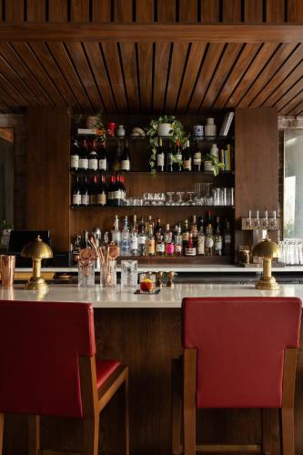 a bar with two red chairs and a counter at Hotel Richemont in Charleston