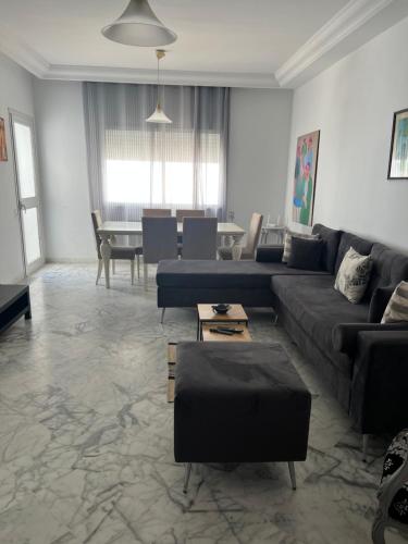 a living room with couches and a dining room at Appartement meublé in La Soukra