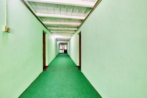 Un pasillo de una habitación vacía con un pasillo verde. en Hotel O Chaman, en Manali
