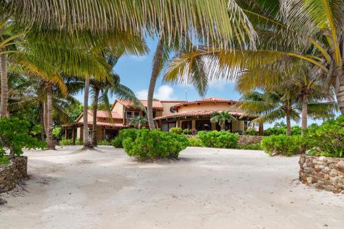 a house on the beach with palm trees at Seascape Villas in San Pedro