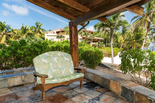a chair sitting on a patio with palm trees at Seascape Villas in San Pedro