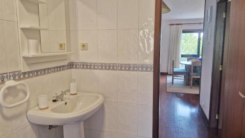 Un baño blanco con lavabo y espejo. en Gerês ZEN by Gerês Casas, en Gerez