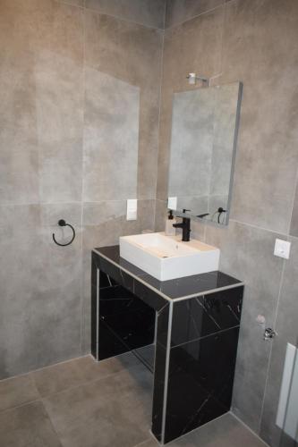 a bathroom with a sink and a mirror at Casa Elia AXD in Alexandroupoli