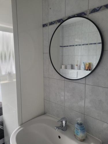 a bathroom with a sink and a mirror at Ferienwohnung am Stadtpark in Erding