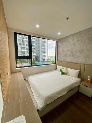 a bedroom with a large bed with a large window at Hue Oi 5 Homestay - Spacious 2-Bedroom Apartment with Balcony & Pool in Hue