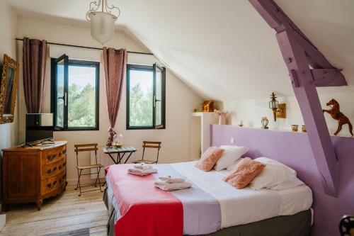 a bedroom with a large bed in a attic at CHAMBRES D HÔTES ROMANCE AVEC SPA PRIVATISÉ ! Le LUXE EN TOUTE INTIMITÉ in Doutre