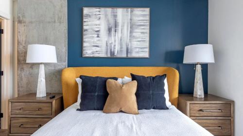 a bedroom with a bed with blue walls and two lamps at Landing at Park and Main - 2 Bedrooms in Centra... in Feather Sound