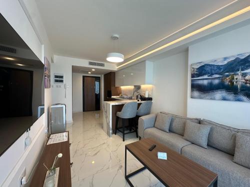a living room with a couch and a table at Grand Sapphire One Bedroom Luxury Residences By MyGuest Cyprus in Iskele