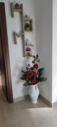 a vase filled with red roses in a wall at Holiday Home Yaya in Scafati