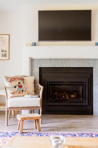 a living room with a fireplace with a television above it at Lodge Condo 35 in Stowe Fork