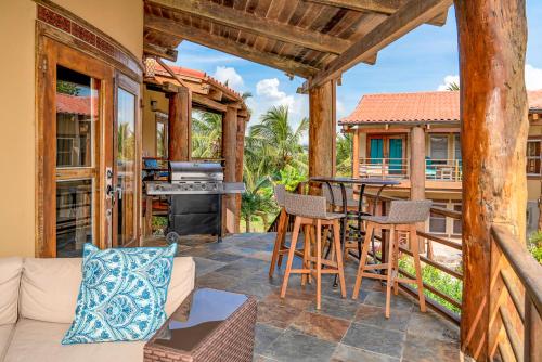 a porch with a couch and a table and chairs at Seascape Villas in San Pedro