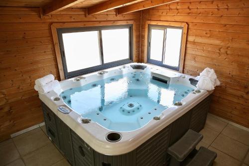 a jacuzzi tub in a log cabin at בקתות ההוד in Kallanit