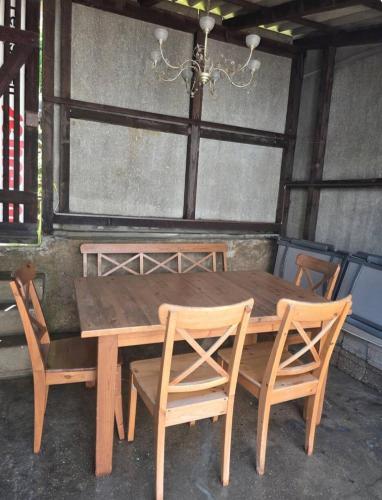 una mesa de madera con 4 sillas y una lámpara de araña en Ferienzimmer in bad friedrichshall, en Bad Friedrichshall