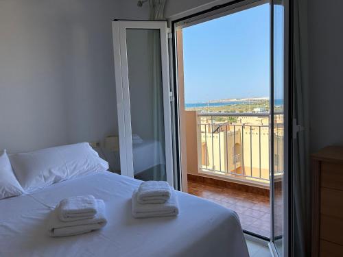 a bedroom with a bed with two towels on it at San Miguel Apartamentos in El Ejido