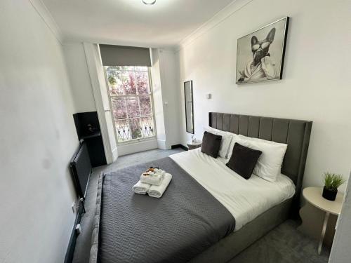 a bedroom with a large bed with a tray on it at Magic Stay Rooms in London