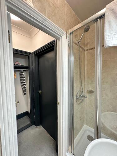 a bathroom with a shower and a glass door at Magic Stay Rooms in London