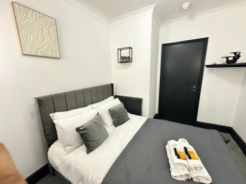 a bedroom with a bed with two towels on it at Magic Stay Rooms in London