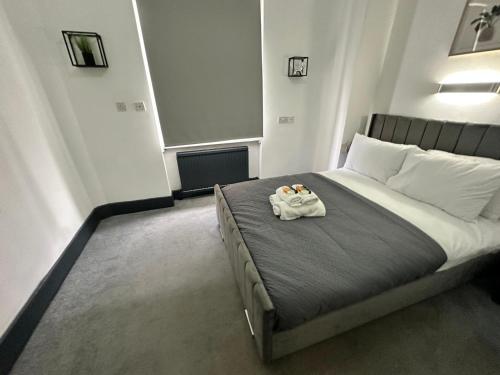 a bedroom with a bed with two towels on it at Magic Stay Rooms in London