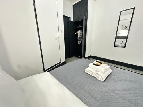 a bedroom with a bed with a towel on it at Magic Stay Rooms in London