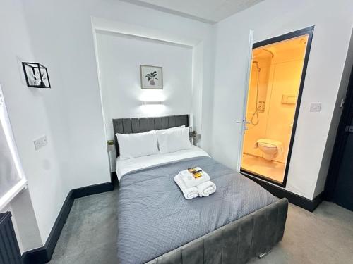 a bedroom with a bed with a towel on it at Magic Stay Rooms in London