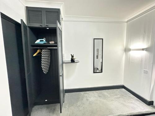 a room with a black cabinet and a white wall at Magic Stay Rooms in London