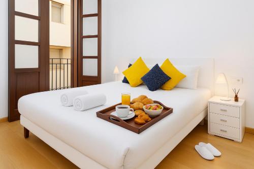 un letto con un vassoio di cibo sopra di Grand Central Market Suites By VALENCIAFLATS EU a Valencia