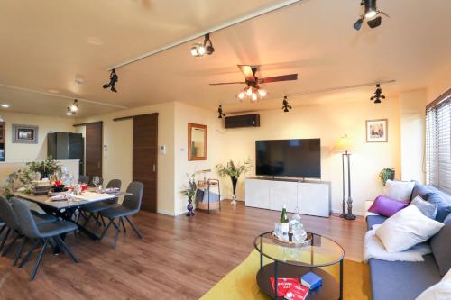 a living room with a couch and a dining room at ラグジュアリー戸建貸切,羽田,品川まで20分 3ベットルーム 広々リビングのモダンクラシックな一棟貸し in Tokyo