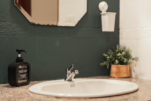 a bathroom sink with a soap dispenser on it at Areca Holiday Home 8, Bangtao Beach in Ban Thalat Choeng Thale