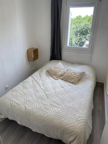 a small bed in a bedroom with a window at Appartement 5 places 300m de la plage in Argelès-sur-Mer